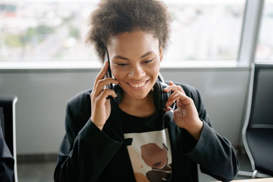 Kvinne smiler i telefonen